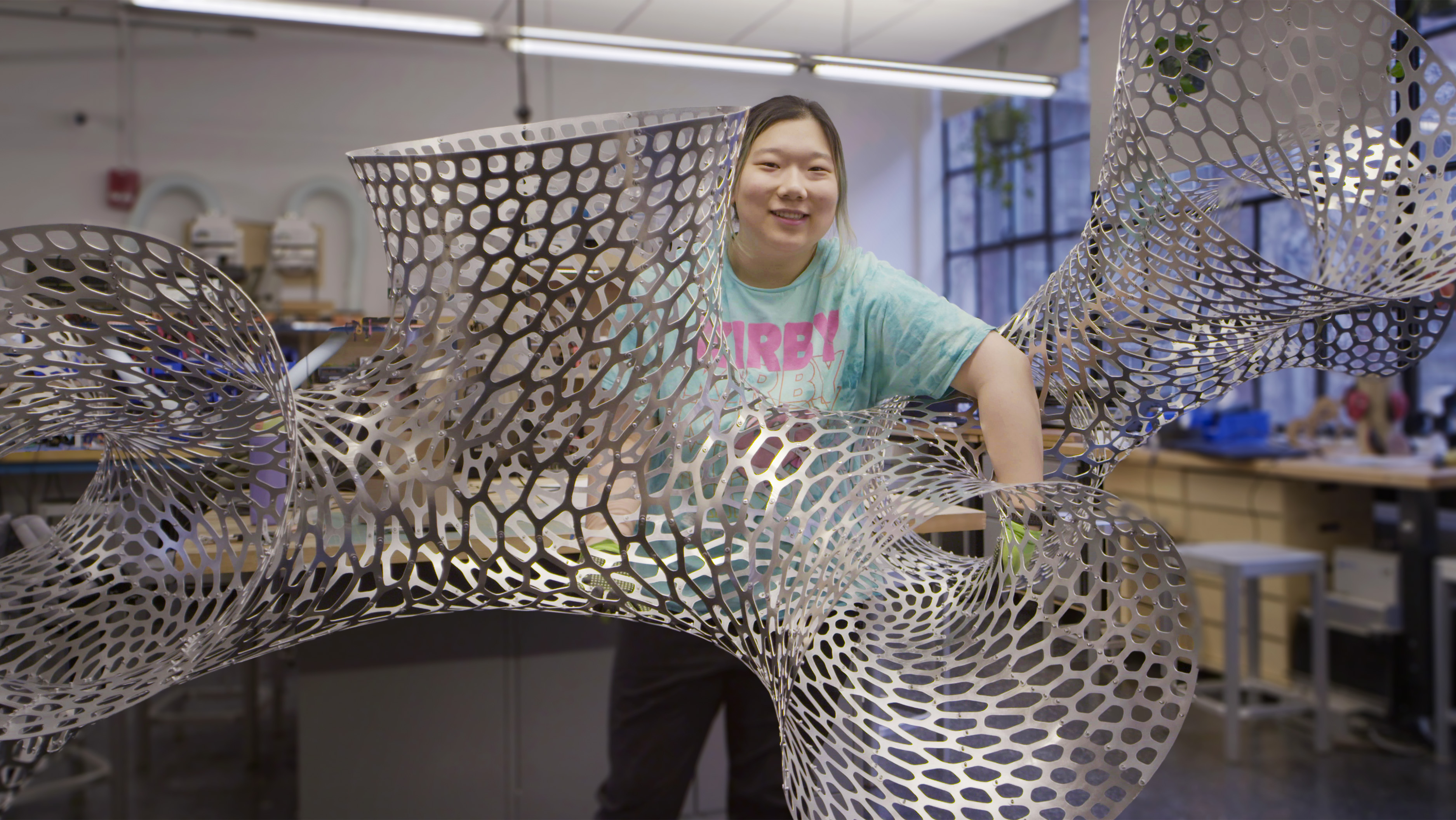student holds a metal structure