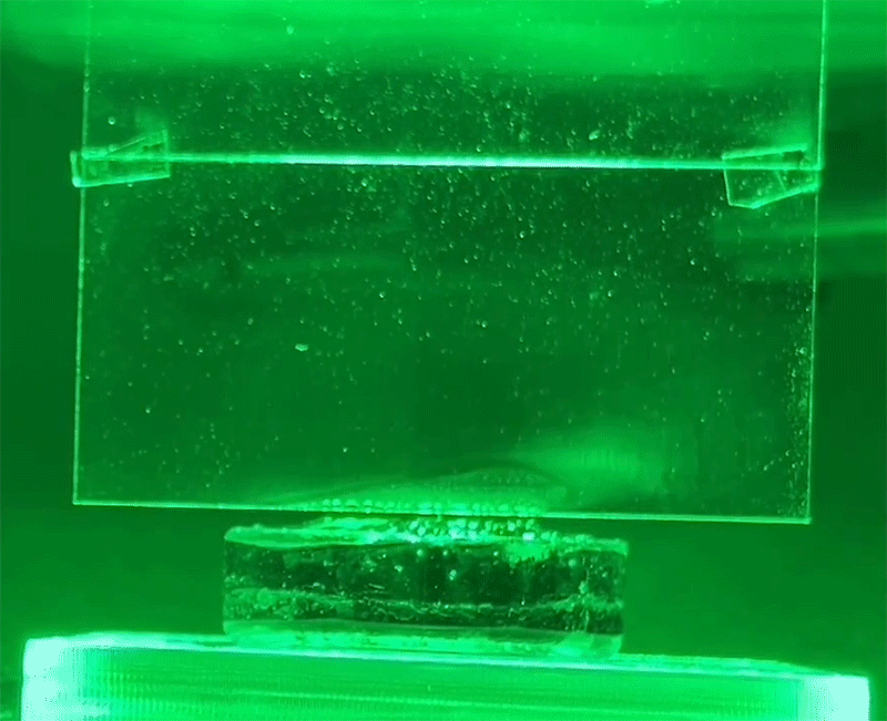 Animation shows evaporating by white condensation on glass under green light.