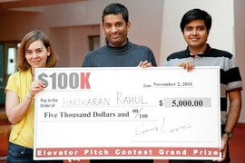 three people holding big check