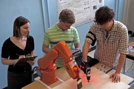 Professor Julie Shah observes while grad students Ron Wilcox (left), and Matthew Gombolay coordinate human-robotic interaction.
