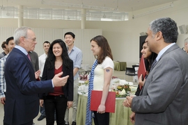 MIT President L. Rafael Reif, left, mingled with the SuperUROP students at the year-end reception for nearly 80 SuperUROP graduates in celebration of their completion of the Advanced Undergraduate Research Opportunities Program in EECS. EECS Department Head and creator of SuperUROP Anantha Chandrakasan is standing on the right.