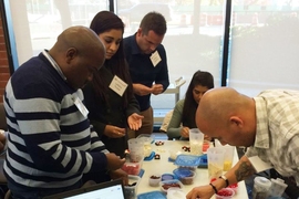 MIT Professional Education students from South Africa use Lego bricks in a manufacturing game to assemble small cars.