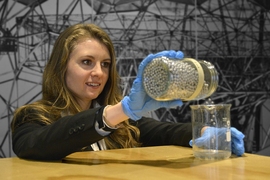 Jean Sack demonstrates the aluminum-water reaction utilized by her Beaver Works team. The pellets she is reacting with water are made from aluminum alloyed with metals from group 13 in the periodic table.