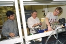 Left to right: Rubaiyat Amin Kahn, Professor Clark  Colton and Richard West work with the heat exchanger in a chemical engineering  lab. The machine can also be controlled remotely over the web.