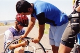 Taku Iida (standing) helps Kyle Rattray repair his second flat tire, just outside Billings, Mont.