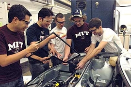 Left to right: Gerardo Lao, grad student in material science, Emmanuel Sin, mechanical engineering senior, Ryan King, mechanical engineering sophomore, Jeremy Kuempel, freshman in mechanical engineering, Craig Wildman, graduate student in mechanical engineering team around the porsche in Sloan Automotive Lab. They are installing batteries in the front trunk compartment of the vehicle.