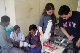 MIT students Maria Luckyanova and Philip Garcia (at right) operate their prosthetic-fitting device at the Jaipur Foot Organization headquarters in India in January, as JFO specialists work on fitting a prosthetic leg on a patient.