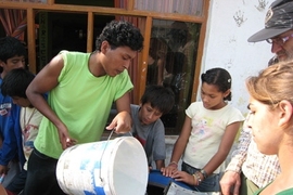 MIT students and residents of Ventanilla, Peru work on the bicilavadora, a novel, inexpensive bike/washing machine.