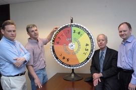 Ronald Prinn, director of MIT's Center for Global Change Science, and his group have revised their model that shows how much hotter the Earth's climate will get in this century without substantial policy change. Standing with the group's "roulette wheel" are, from left to right, Mort Webster, professor in the Engineering Systems Division; Adam Schlosser, principal research scientist at the Center ...