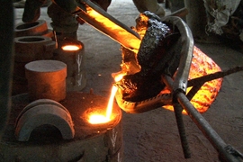 D-Lab Scale-Ups fellow Kwami Williams (&#39;12) and Ghanaian master blacksmith Stone Musah at work in Ghana pouring molten cast iron into a mold to create an auger. The auger was incorporated into a press used to extract oil from Moringa seeds.