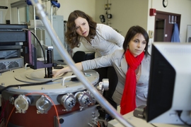 Laura Popa (left) and Dana Weinstein test their experimental chip using a cryogenic vacuum radio-frequency probe station.
