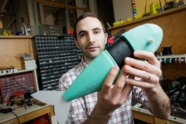 Andrew Marchese, doctoral candidate in EECS at MIT, holds a soft robotic fish developed by the Distributed Robotics Laboratory.