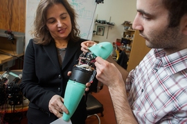 Andrew Marchese, doctoral candidate in EECS at MIT (right), and Dr. Daniela Rus, professor in EECS and Director of CSAIL, hold a soft robotic fish developed by the Distributed Robotics Laboratory. 