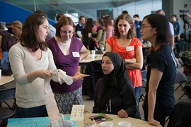(Right to left) Katherine Ong (MIT PhD student in mechanical engineering), Liz Slavkovsky, Marzyeh Ghassemi (seated, MIT PhD student in electrical engineering and computer science), Shannon Fry, and MIT alumna Cynthia Lu '12 from Vecna Technologies are members of the Helping Hands team. They are second-place winners for their wearable milk expression bra. 