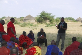 An employee of Global Cycle Solutions introduces a solar lamp to villagers in rural Tanzania.