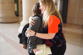 TMAYD founder Izzy Lloyd (right) gives a friend a hug after asking about her day.