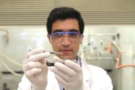 Seyed Mirvakili, lead author of the paper describing the niobium supercapacitors, examines a strand of the material in the lab.