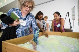 Attendees learn about various projects, including the AR Sandbox, a real-time topographical map made of moveable sand. 