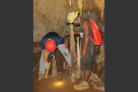 University of Massachusetts professor Stephen Burns (left) and Malagasy student Peterson Faina cutting a stalagmite at Anjohibe Cave.  