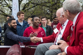 Peter Miller ’62 (left) and Oliver Smoot ’62 (right) shake hands with spectators, while in the grand marshall’s car.