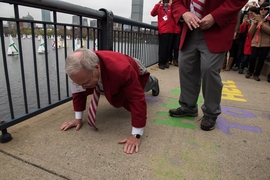 Oliver Smoot ’62, whose body length was used to measure the bridge over the Charles River near MIT, in a noted 1958 prank by MIT students, demonstrates how he did it. Smoot served as grand marshall in the “Crossing the Charles” procession and competition.