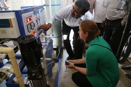 CB Nataraja, a representative from Tata Projects Limited, shows PhD candidate Natasha Wright one of the company's existing on-grid, reverse-osmosis desalination systems in a rural village north of Hyderabad, India.