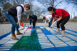 “Together in Service gives the MIT community the opportunity to see some of the vital work that Cambridge and Boston-area nonprofits are doing, and to make a personal contribution to their efforts,” said Kate Trimble, co-chair of Together in Service Day and director of the Priscilla King Gray Public Service Center. Pictured, volunteers for CitySprouts spray paint stakes that children can place...