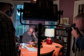 Surrounded by Boston-area camera crews at his home early this morning, Rainer Weiss speaks on the phone with international journalists assembled at the Nobel Foundation's press conference in Stockholm, Sweden.