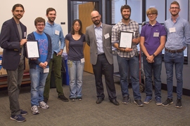 At center is Mike Tarkanian, a senior lecturer in the Department of Materials Science and Engineering and MADMEC competition organizer. Flanking him are two teams, Geoworks (left) and DUMBLEDORE (right), which split second and third place prizes of $7,000 and $5,000.