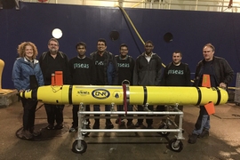 Scientists get ready to load an AUV onto a research vessel for a test of navigation and sensing algorithms at sea.