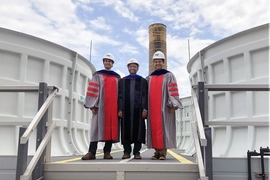 Kripa Varanasi, associate professor of mechanical engineering, poses on the roof of the Central Utility Plant with the two doctoral students who led the research project, Maher Damak (left) and Karim Khalil (right), just after receiving their doctoral hoods this week.