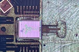 The clock transmitter chip (pink) wired to a circuit board package. Connected is a metal gas cell (right), in which a 231.061 GHz signal generated from the chip excites the rotation of carbonyl sulfide molecules. When the molecules reach peak rotation, they form a sharp signal response. That frequency can then be divided down to exactly one second, matching the official time from atomic clocks, th...