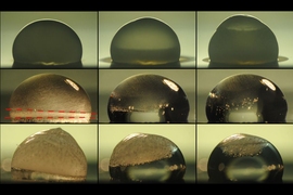 Images of a droplet on a surface show the process of freezing (top row), during which condensation temporarily forms on the outside of the droplet as it freezes. The next two rows show the droplet thawing out on a surface coated with the new layered material. In the middle row, the droplet is heated by the coating immediately upon freezing, and the dashed lines show where the freezing at top is ju...