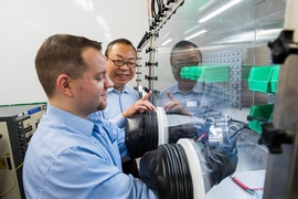 Cadenza Innovation employees Jay Shi, vice president of research and development, and Joshua Liposky, associate director of battery systems, use a moisture-free glove box while working with battery materials in the company’s state-of-the art R&D labs in Bethel, Connecticut.