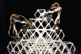 Photo shows two prototype assembler robots at work putting together a series of small units, known as voxels, into a larger structure.