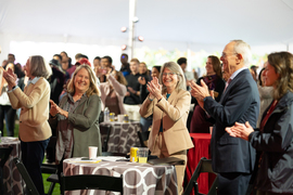 From left to right, Diane Green, Sally Kornbluth, and Rafael Reif stand and applaud amid the crowd