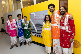 Six members of MIT Bhangra pose in front of the exhibit sign in the Maihaugen Gallery.