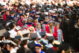 President Sally Kornbluth, Commencement speaker Mark Rober, and MIT leadership wear academic regalia and walk in a procession surrounded by graduates.