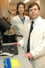 Lincoln Lab/MIT biologists Martha Petrovick and Todd Rider with the centrifuge and luminometer used in the system they and their colleagues developed to improve detection of such pathogens as SARS and anthrax.