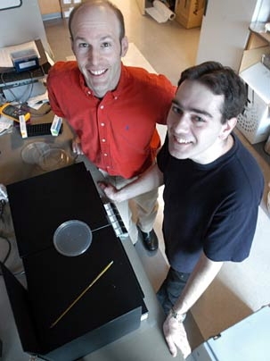 Assistant professor in biology Paul Garrity, left, and graduate student Mark Rosenzweig display fruit fly larvae on a heat table.