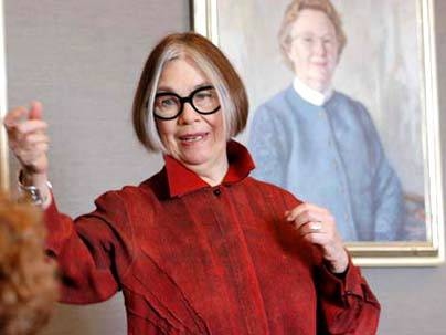 Adele Santos addresses the MIT Women's League on Feb. 18. In the background is a portrait of former MIT First Lady Priscilla Gray.