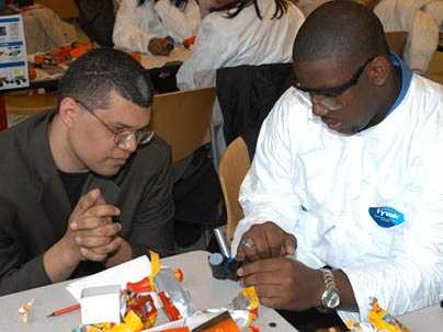 Christopher Banks of Baton Rouge, La., right, examines the workings of a disposable camera under the watchful eye of mechanical engineering Professor Martin Culpepper, during a 'Take-Apart Learning' workshop for high school students held March 24. The workshop was part of "Engineering at MIT is Fun Day," an event hosted in association with the National Society of Black Engineers convention.