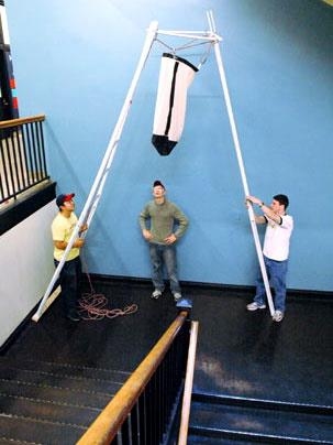 From left, Brian Shieh, James Labuz and Andrew Greenhut prepare their banana-harvesting device for a mockup review in 2.009.