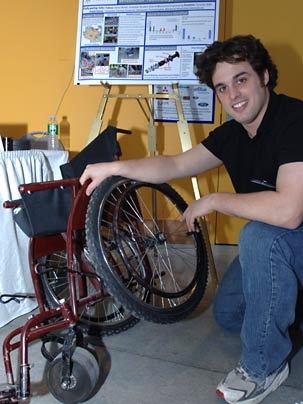 Graduate student Amos Winter displays a wheelchair model currently being produced in Tanzania at a MacVicar Day exhibit March 3 in the Stata Center. Winter is working on technical solutions to the challenges faced by wheelchair users in that country.