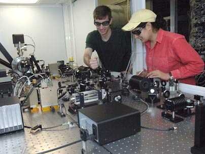 Assistant professor Nergis Mavalvala, right, and Ph.D. student Thomas Corbitt look over the laser system they use to cool a coin-sized mirror to within one degree of absolute zero.