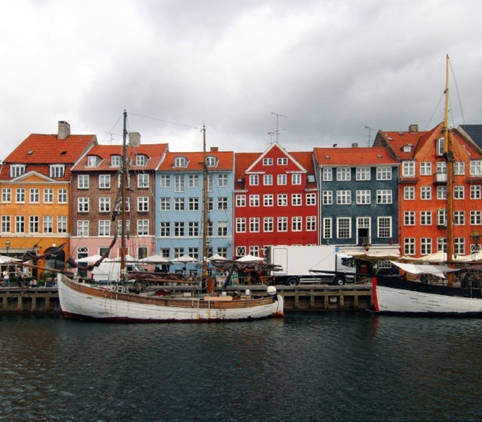 Six brightly colored townhouses in a row built with wood, bricks, and plaster