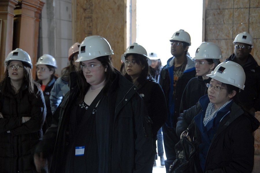 Students inspect the lobby of Maseeh Hall. Maseeh was originally built as a hotel, and the lobby was a passageway for carriages. Its columns still bear grooves from carriage wheels turning against them.