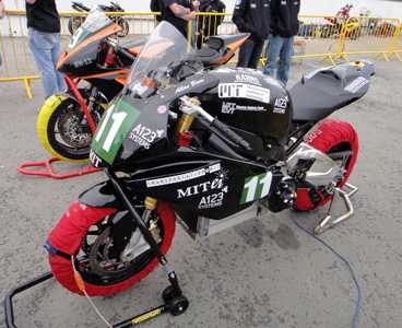 The eSuperbike warms up before a practice round. Team members wrapped the tires to keep them warm, softening the rubber and maximizing tire grip.