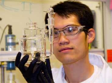 Graduate student Jin Suntivich, lead author of the <i>Nature Chemistry</i> paper, holds up an electrochemical cell used for catalyst testing.