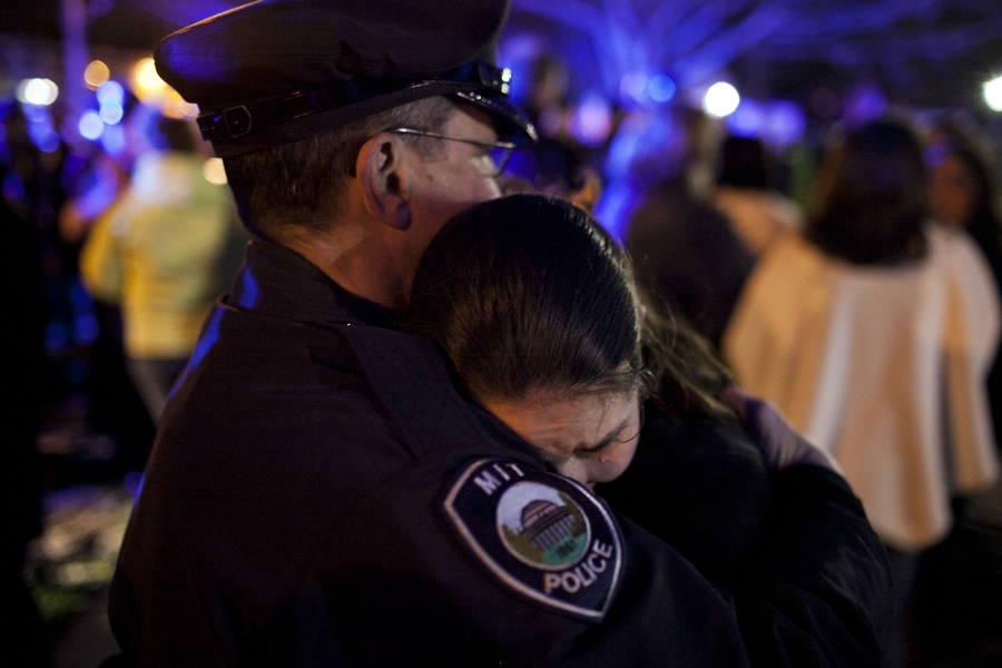 A woman hugs an MIT Police officer after a vigil.